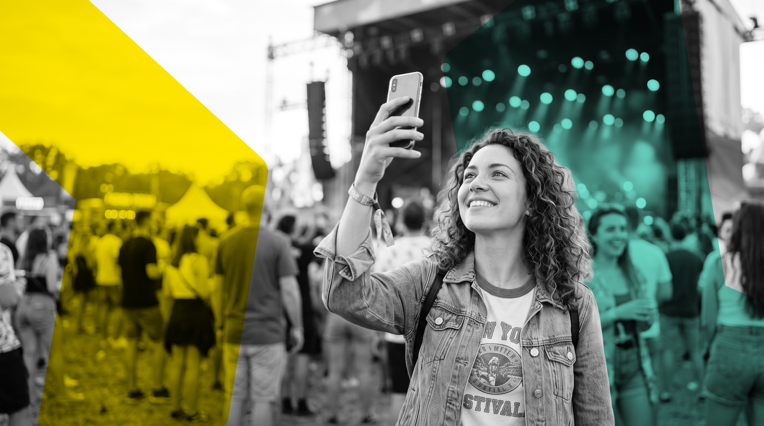 A festival-goer takes a selfie in a colorized crowd, smiling toward the stage.